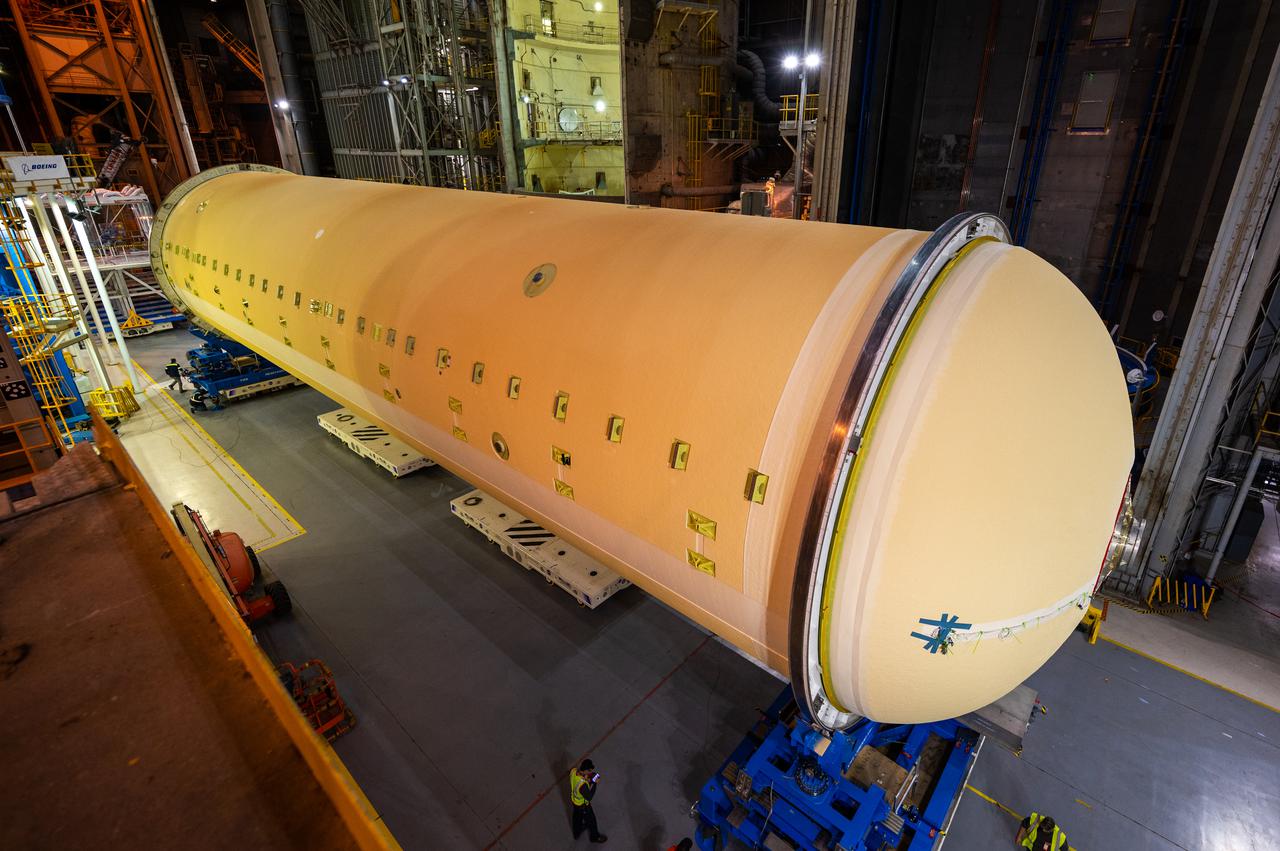 Technicians transported the assembled upper part of the Artemis II core stage to the final assembly area inside the factory at NASA’s Michoud Assembly Facility in New Orleans.  On Jan 10, the forward assembly, left was moved next to the Artemis II liquid hydrogen tank, which has been undergoing assembly. Next, Boeing, the lead core stage contractor, will join the forward assembly and the liquid hydrogen tank to complete most of the core stage for the Space Launch System (SLS) rocket that will send the first crew on an Artemis mission. The core stage consists of five major structures that are built, outfitted, and then connected to form the final stage. The forward skirt, liquid oxygen and intertank were connected and tested to form the 66-foot forward assembly. After the forward assembly is joined with the 130-foot liquid hydrogen tank, only the engine section, the fifth piece of the stage, will need to be added to complete the Artemis II core stage.  The core stage serves as the backbone of the rocket, supporting the weight of the payload, upper stage, and crew vehicle, as well as the thrust of its four RS-25 engines and two five-segment solid rocket boosters attached to the engine and intertank sections. On Artemis II, the SLS rocket will launch the Orion spacecraft and a crew, sending them into lunar orbit, in preparation for later Artemis missions that will enable the first woman and first person of color to land on the Moon.